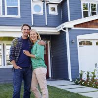 couple in front of a blue house