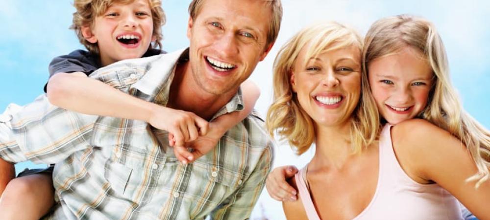 family of four outside smiling